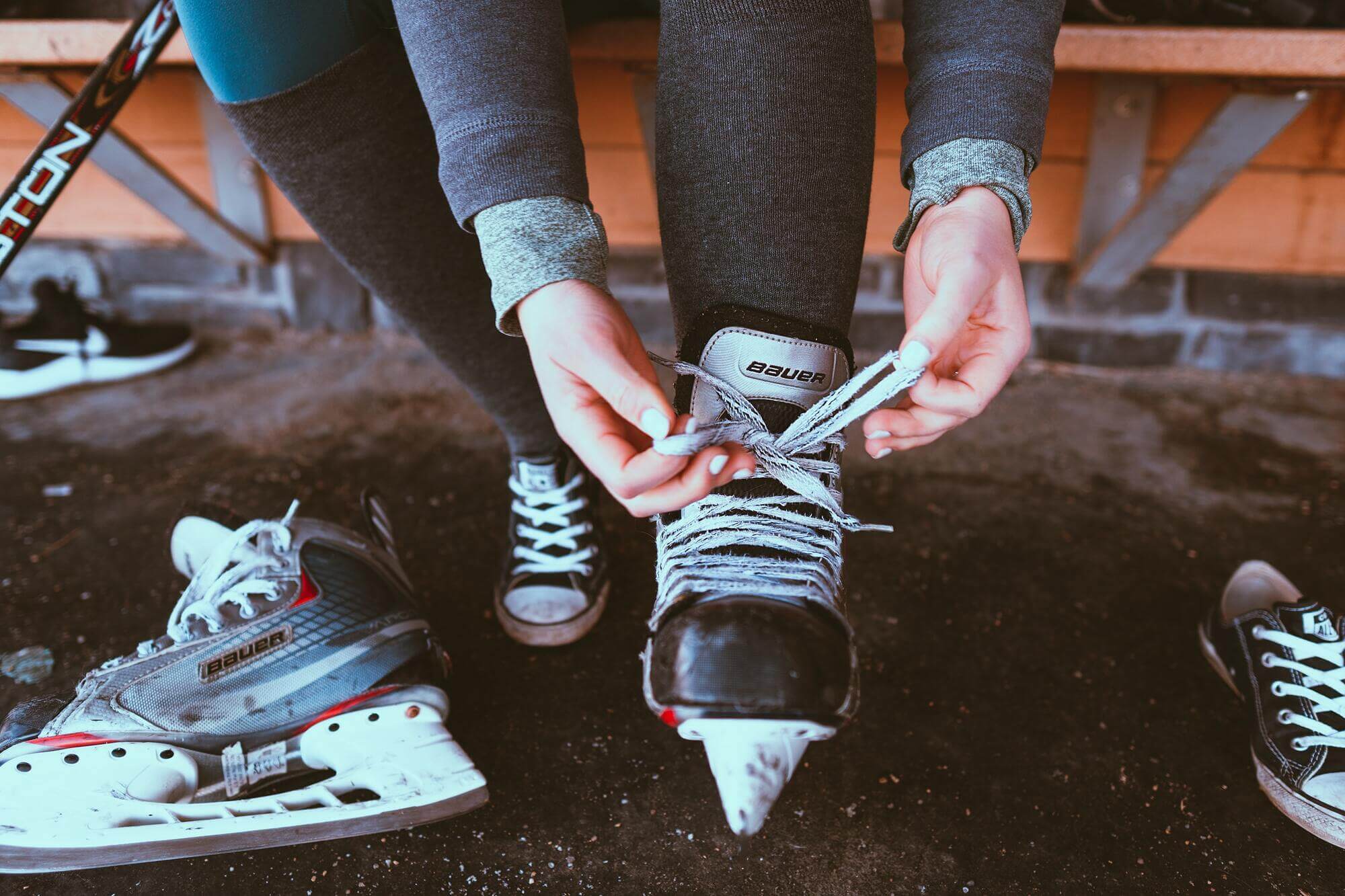 Woman tying hockey skates - stock