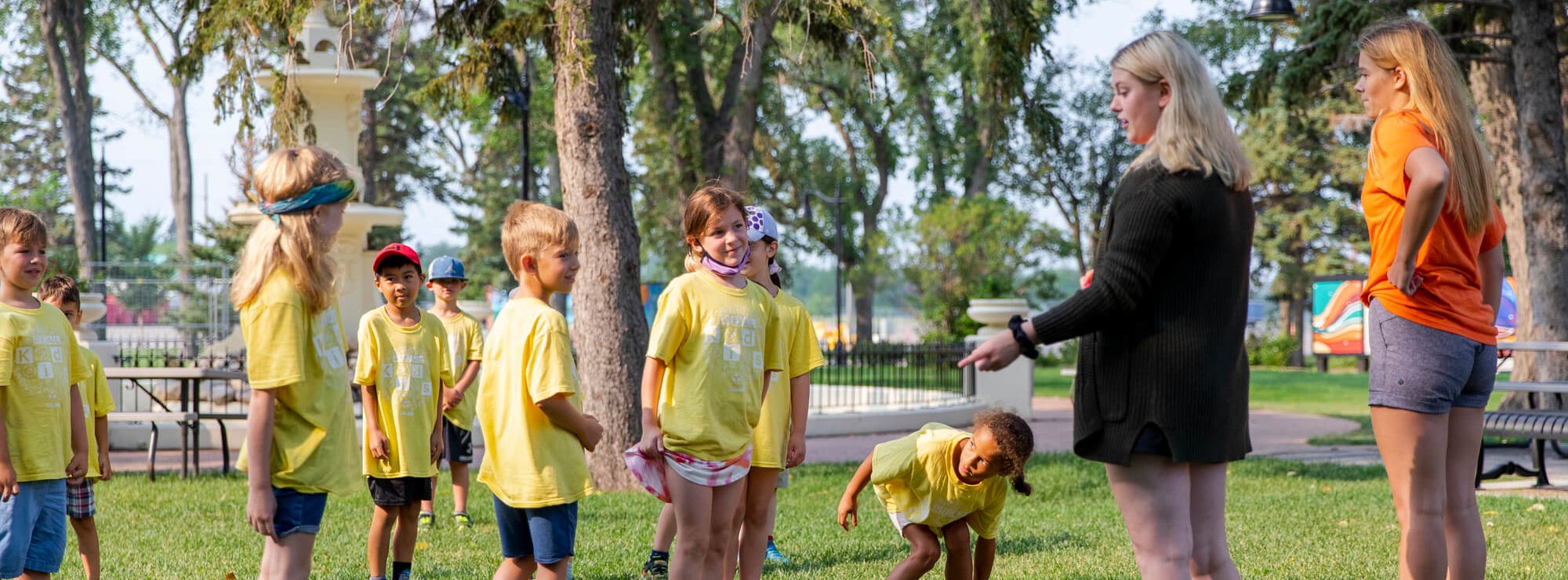 Kid's outside in Confederation Park during a summer camp event at REAL District, Regina