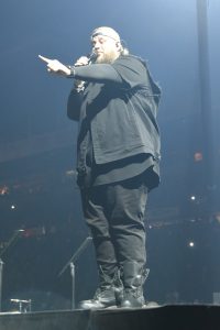 Performer sings passionately on stage during concert.