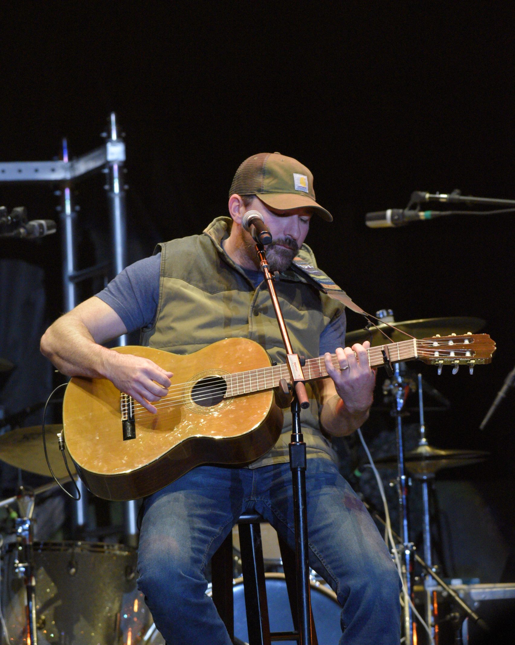 Man playing acoustic guitar on stage.