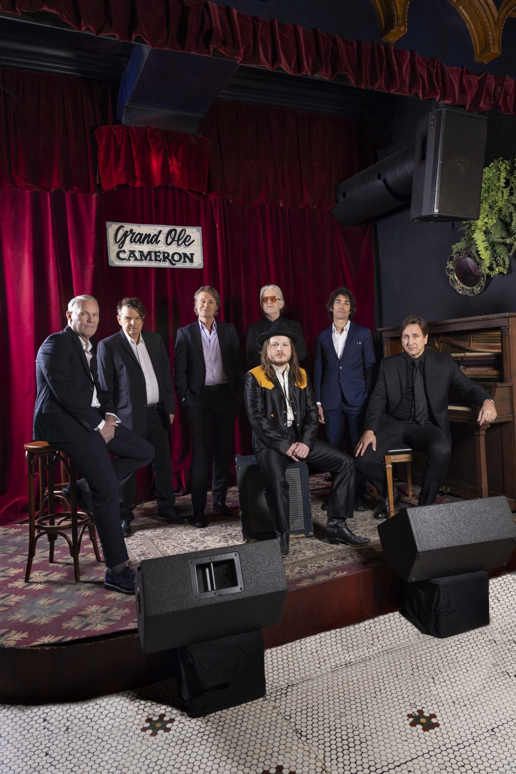 Band posing on stage with instruments.