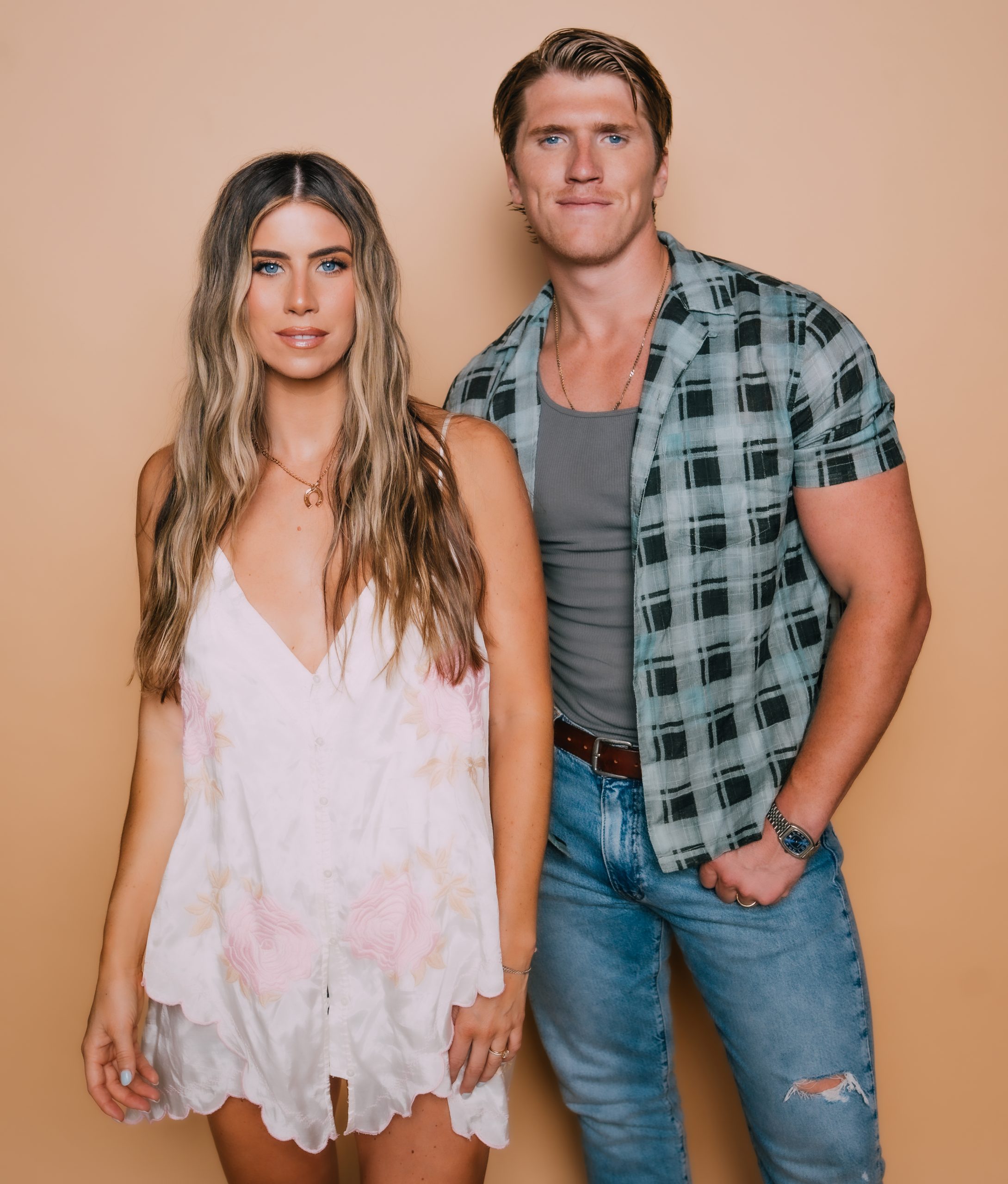 Man and woman posing against orange background
